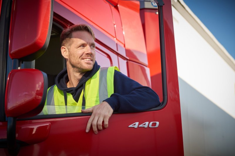 Man in grote rode vrachtwagen